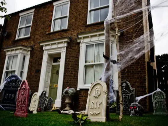 Oudoor image of a house with Halloween graveyard and skull decorations.