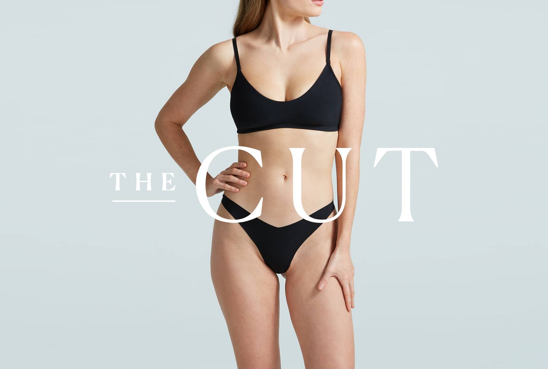 Model wearing the Butter Bralette and Tiny Thong in black with The Cut logo overlayed ontop of the image.