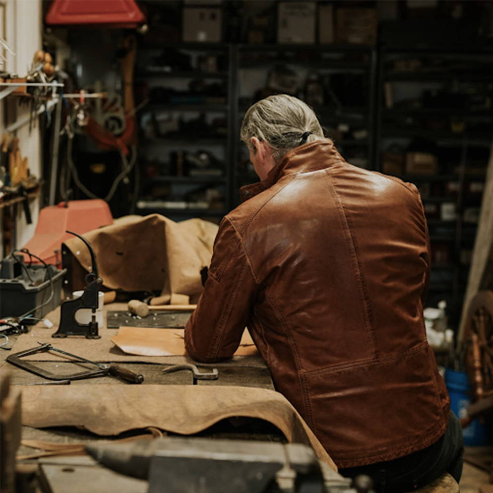 man working while wearing a leather jacket