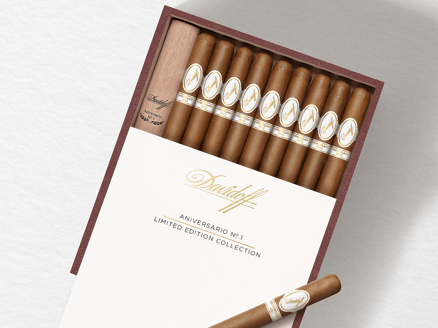 Geöffnete Kiste mit zehn Davidoff Aniversario No. 1 Zigarren drin, von denen eine in einem Holztubo ist. Eine Zigarre ist obendrauf platziert. 