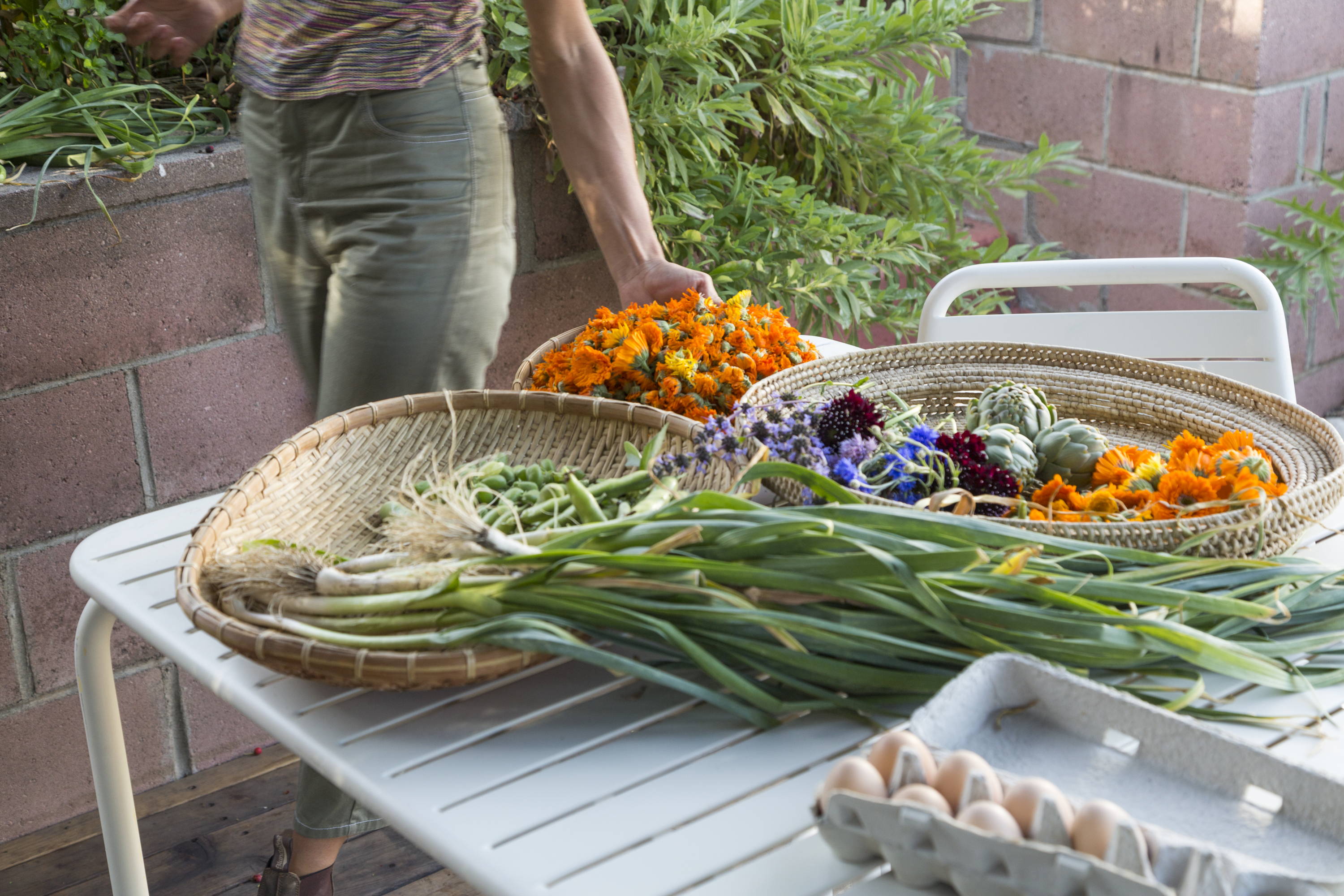 Fresh produce spread out on white Floyd patio table