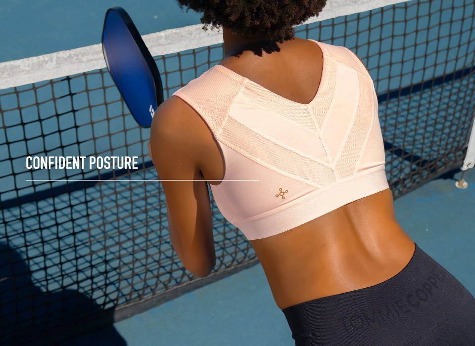 A woman wearing the Shoulder Support Bra while playing pickleball