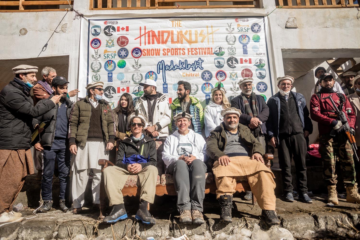 Group of people posing in front of a colorful banner.