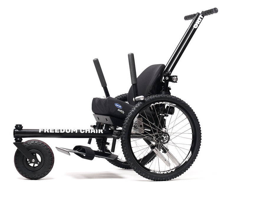 GRIT Junior pediatric rugged lever wheelchair shown with push handles, footplate, levers, molded seatback, and mountain bike tires