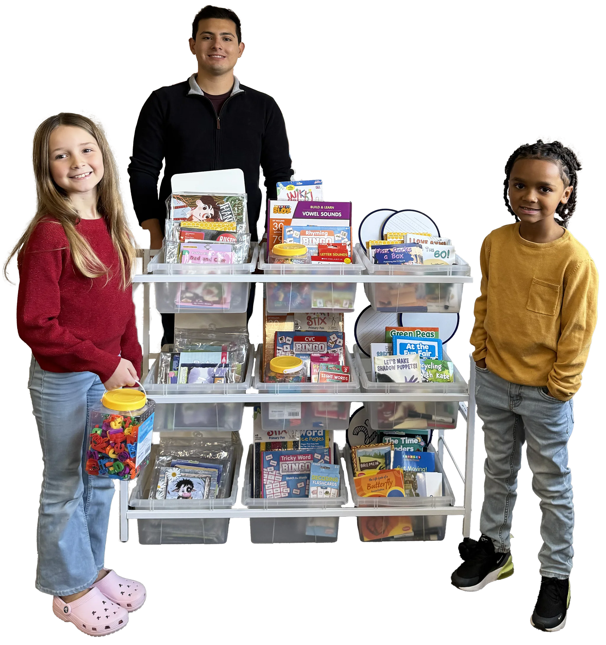 Three individuals stand beside a cart filled with educational books and materials.