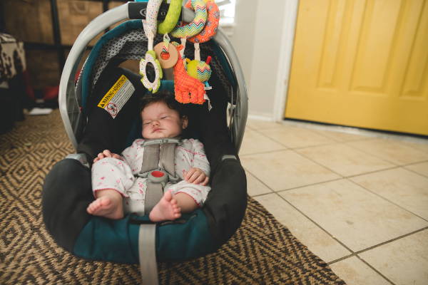 Small baby sleeping in car seat alone