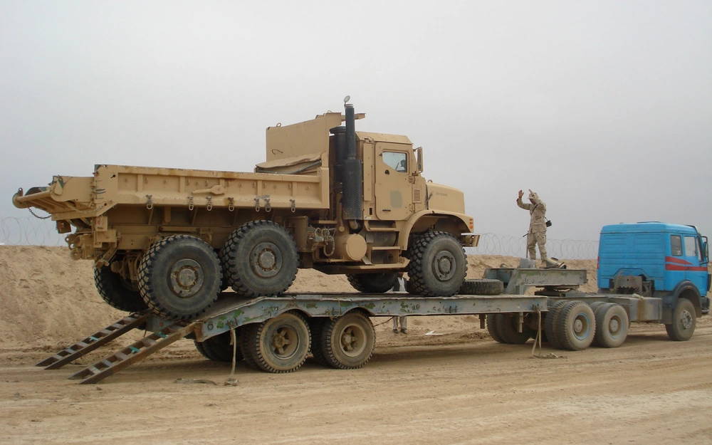 U.S. Navy Equipment Operator 1st Class Perry Dwayne Tiatano, assigned to Naval Mobile Construction Battalion (NMCB) 5, guides a medium tactical vehicle replacement onto a trailer April 13, 2009, in Helmand province, Afghanistan. The vehicle was to be hauled to a remote forward operating base in southern Afghanistan. NMCB-5 was deployed to Afghanistan in support of the International Security Assistance Force. (U.S. Navy photo by Construction Electrician 3rd Class Jennifer Janzen/Released)