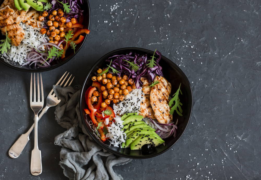 A healthy meal set out on a table with silverware next to it.