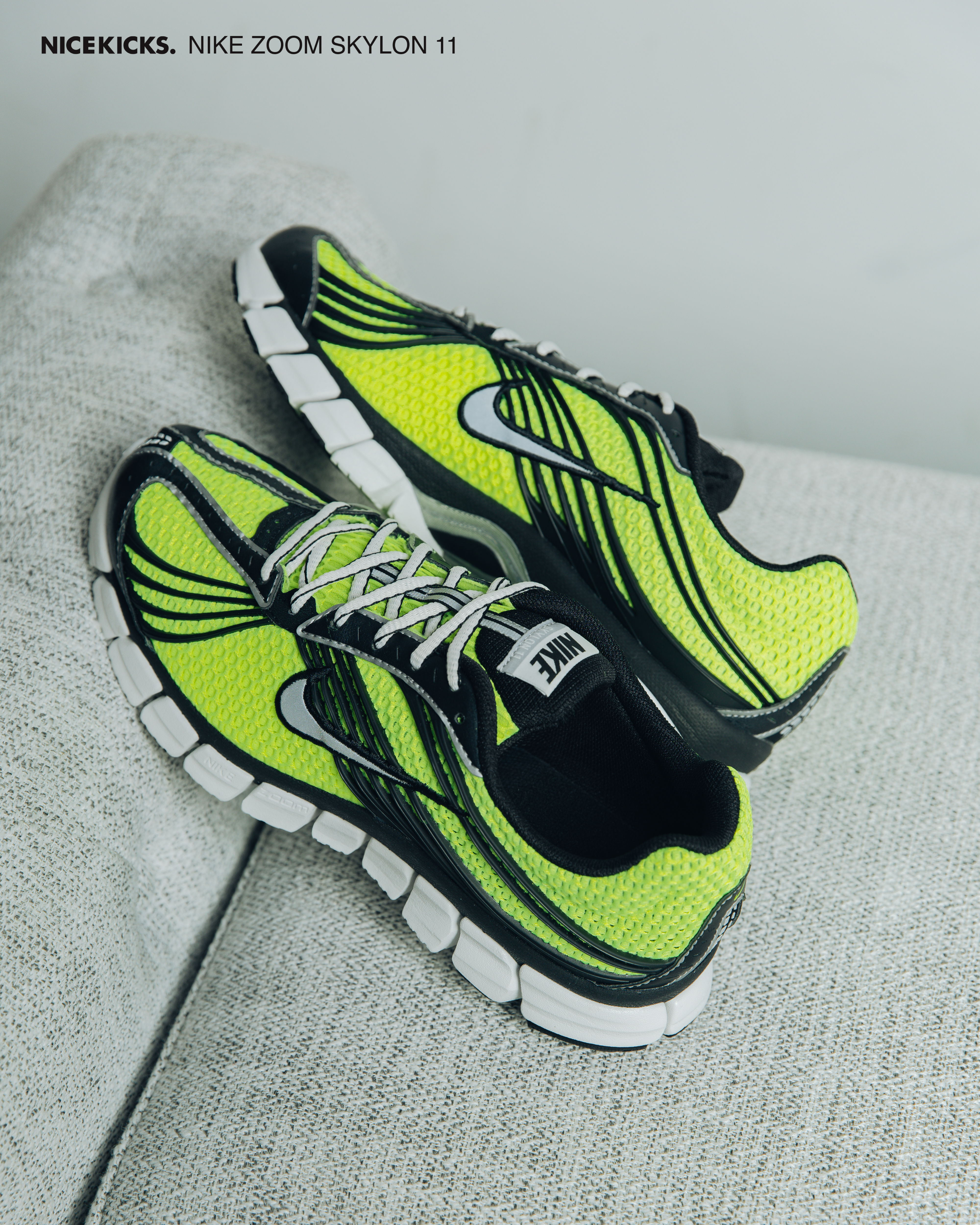 Nike Zoom Skylon 11 sneakers in black and neon yellow on a gray surface.