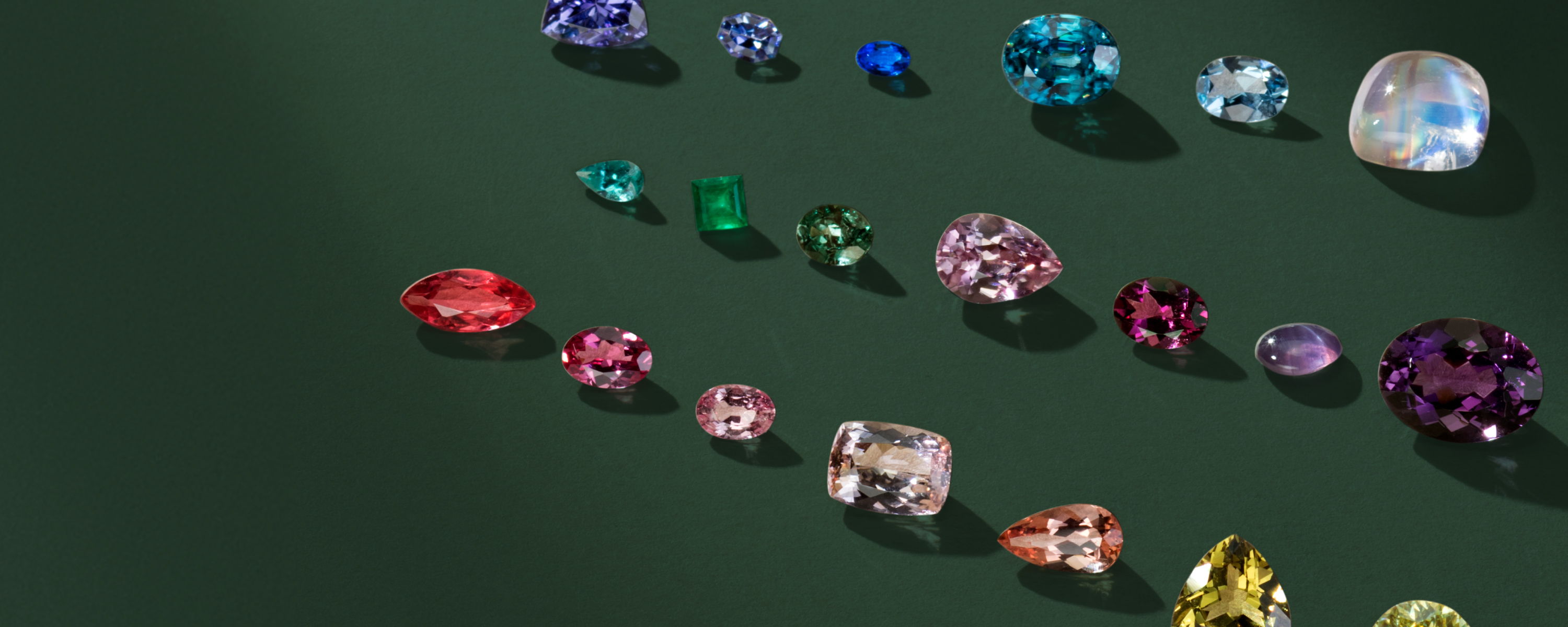 A variety of colorful gemstones arranged on a dark background.