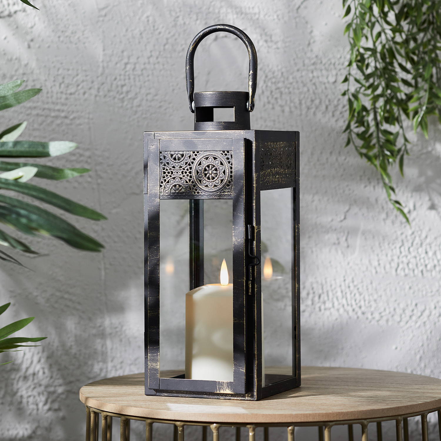 Nador Moroccan garden lantern sat on table and illuminated 