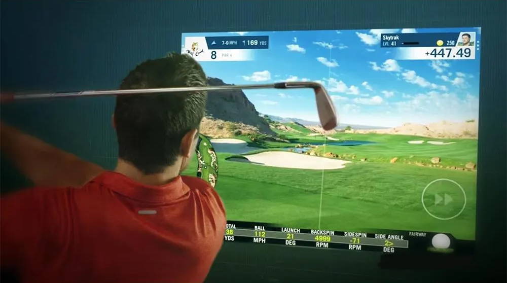Golfer using a SkyTrak home golf simulator