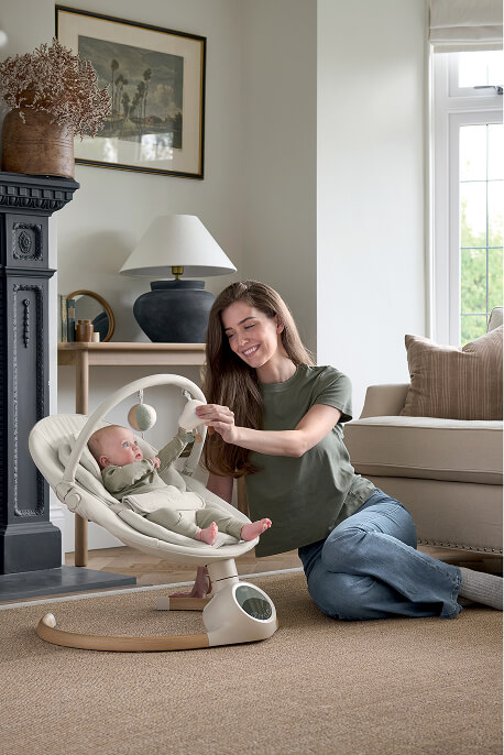 A woman interacts with a baby in an Alto Smart Swing - Cashmere