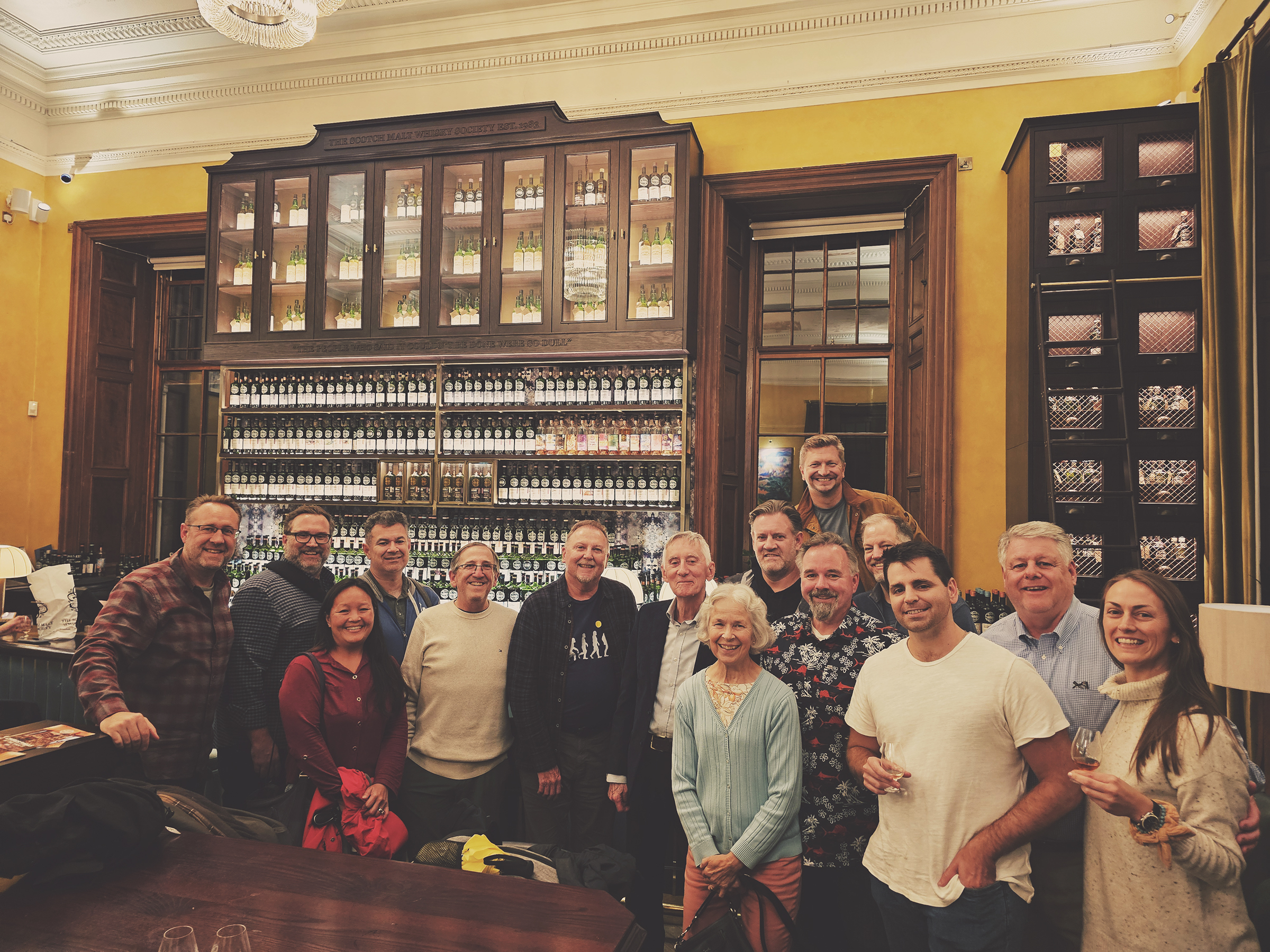 Group of people posing together in a warmly lit room.