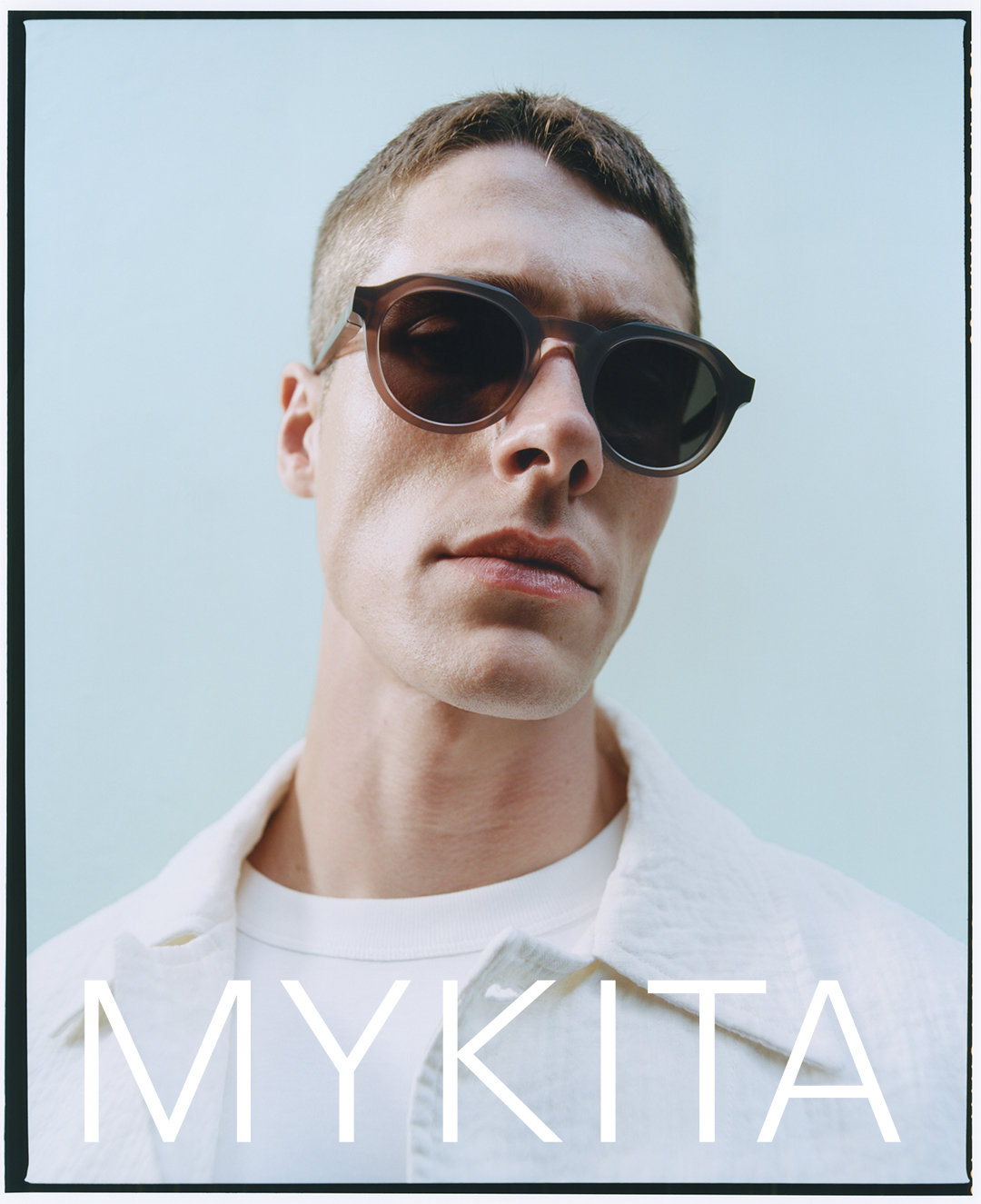 A person wearing sunglasses with the text 