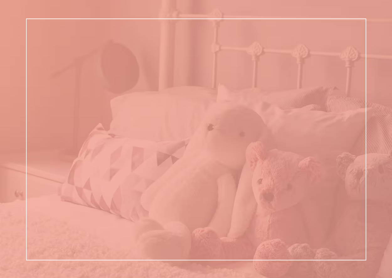 Plyšové hračky a krásné polštáře na posteli s bílým rámem – potenciální horké místo pro roztoče a příznaky alergie na prachové roztoče