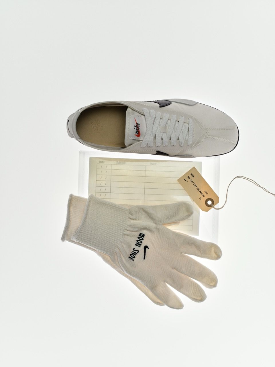 A white sneaker and a glove on a notepad.