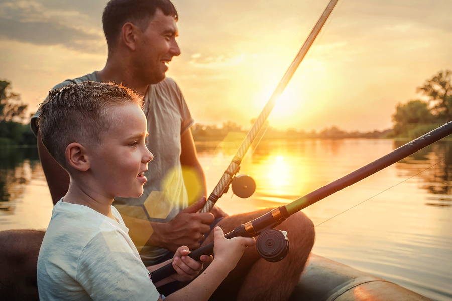 man and boy fishing during golden hour