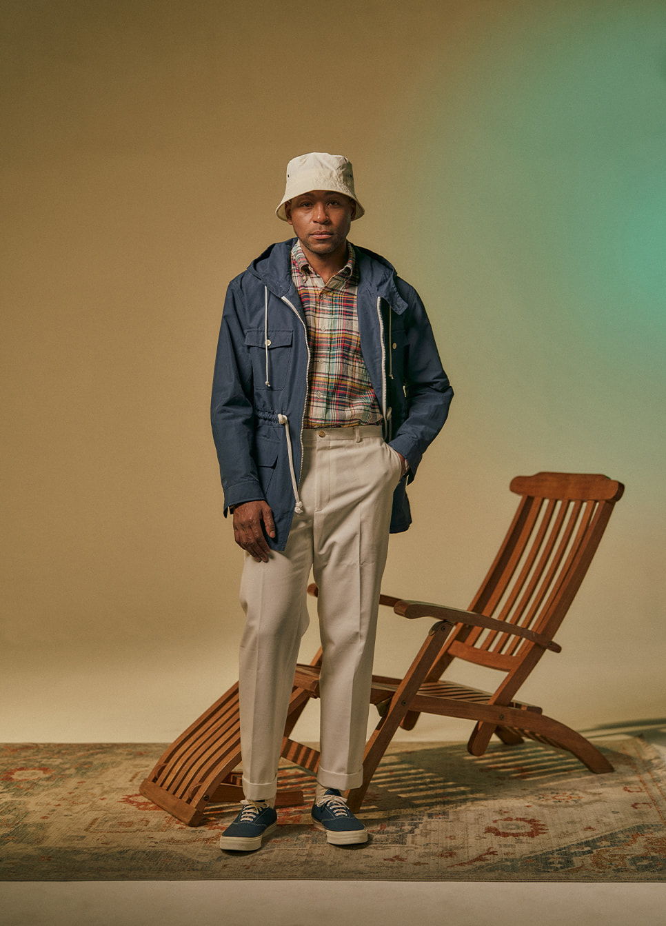 Person in casual outfit standing beside a wooden chair on a rug.