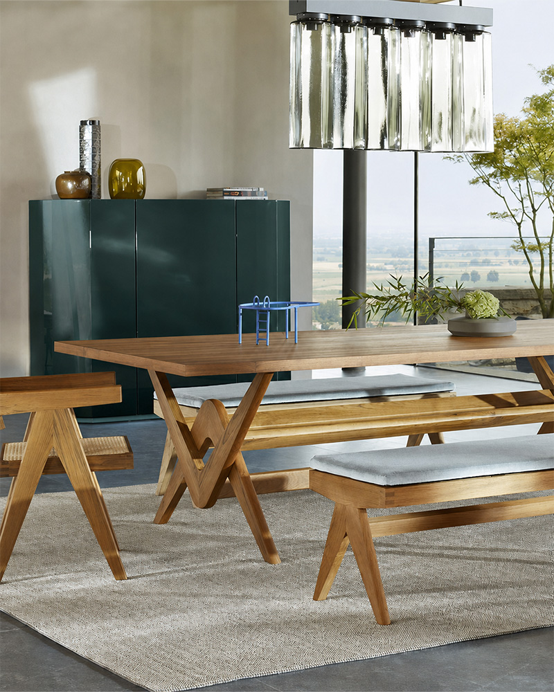A modern Cassina dining table with a glass top and wooden base.