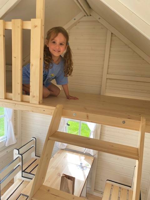 Outdoor Playhouse inside view with kids furniture and a wooden loft by WholeWoodPlayhouses