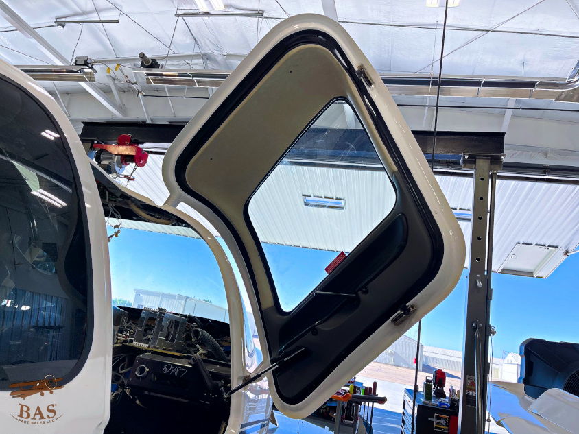 Open aircraft door in a hangar with blue sky visible.