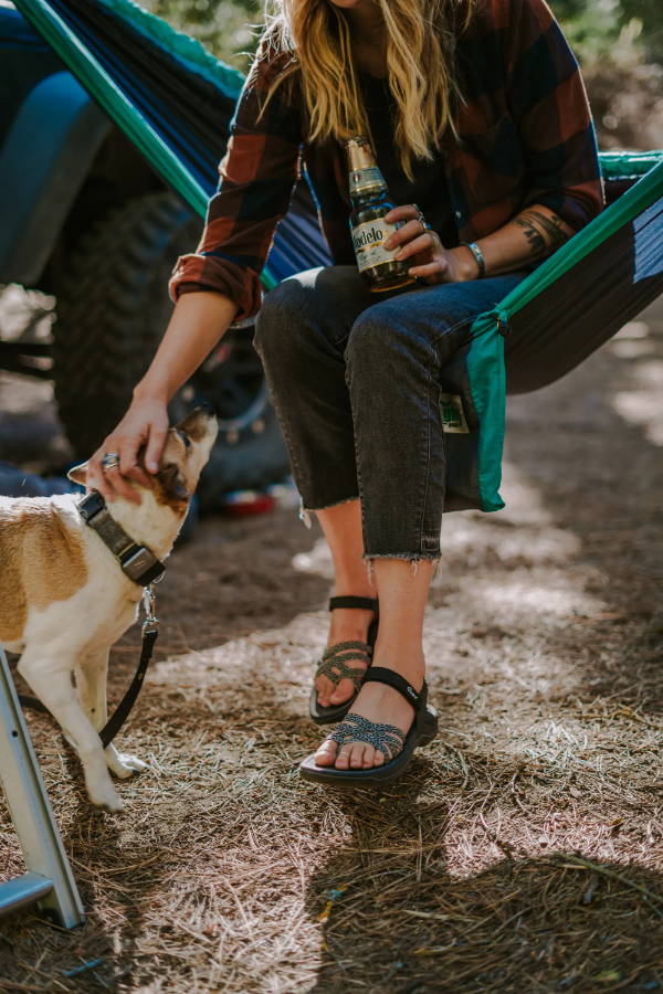 woman wearing cute sandals petting a dog