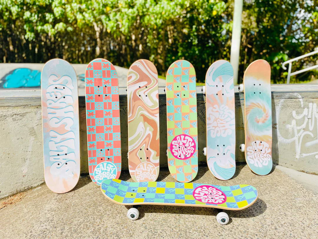 Skateboard completes lined up against a wall.