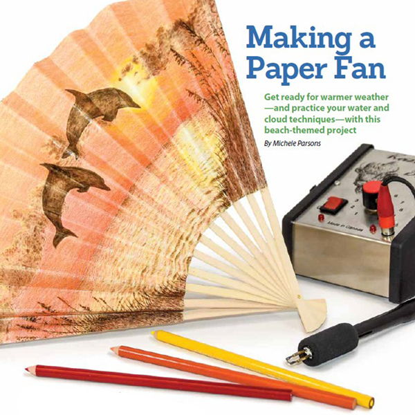 A paper fan, colored pencils, and a crafting tool for making fans.