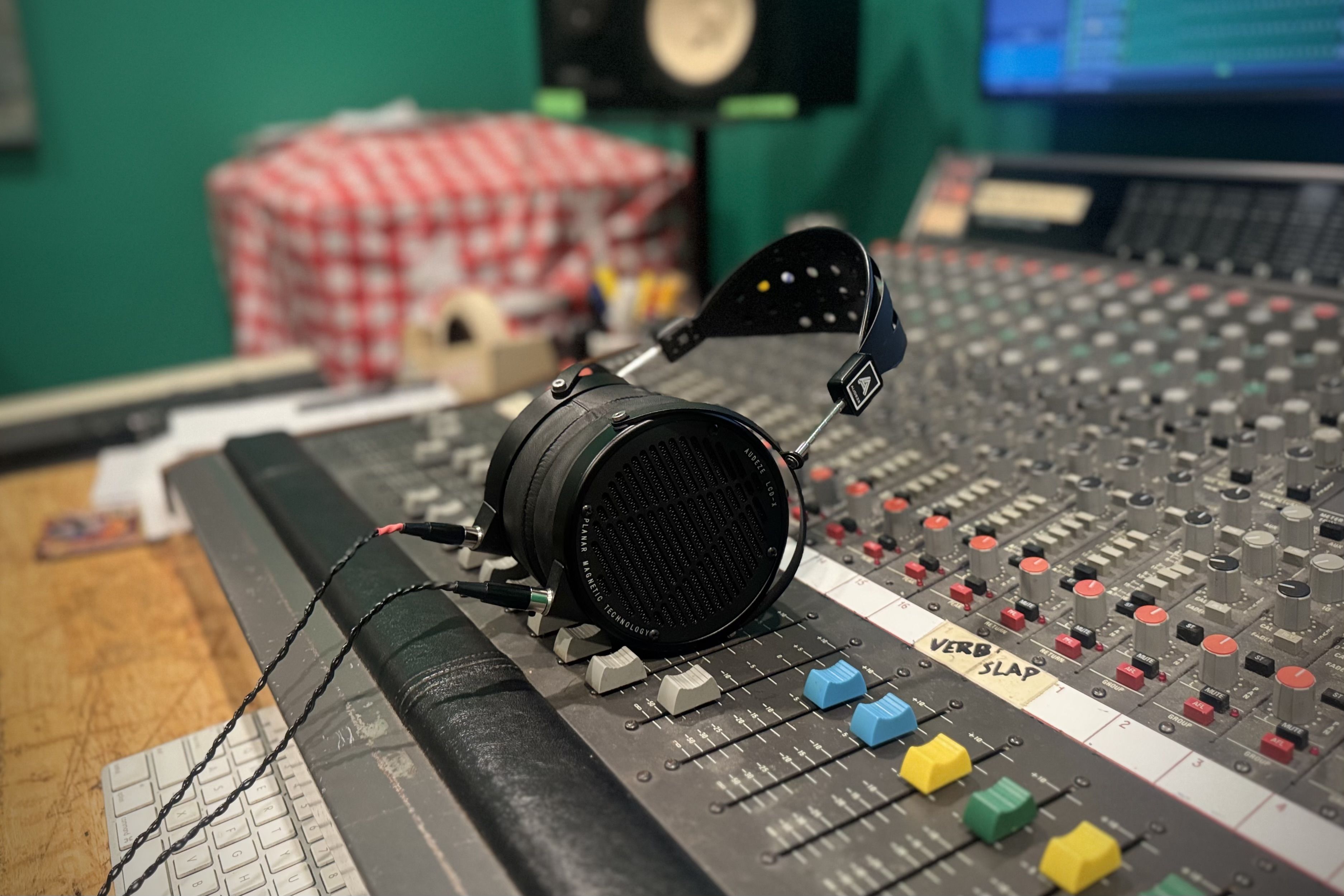 Headphones resting on a sound mixing console in a recording studio.