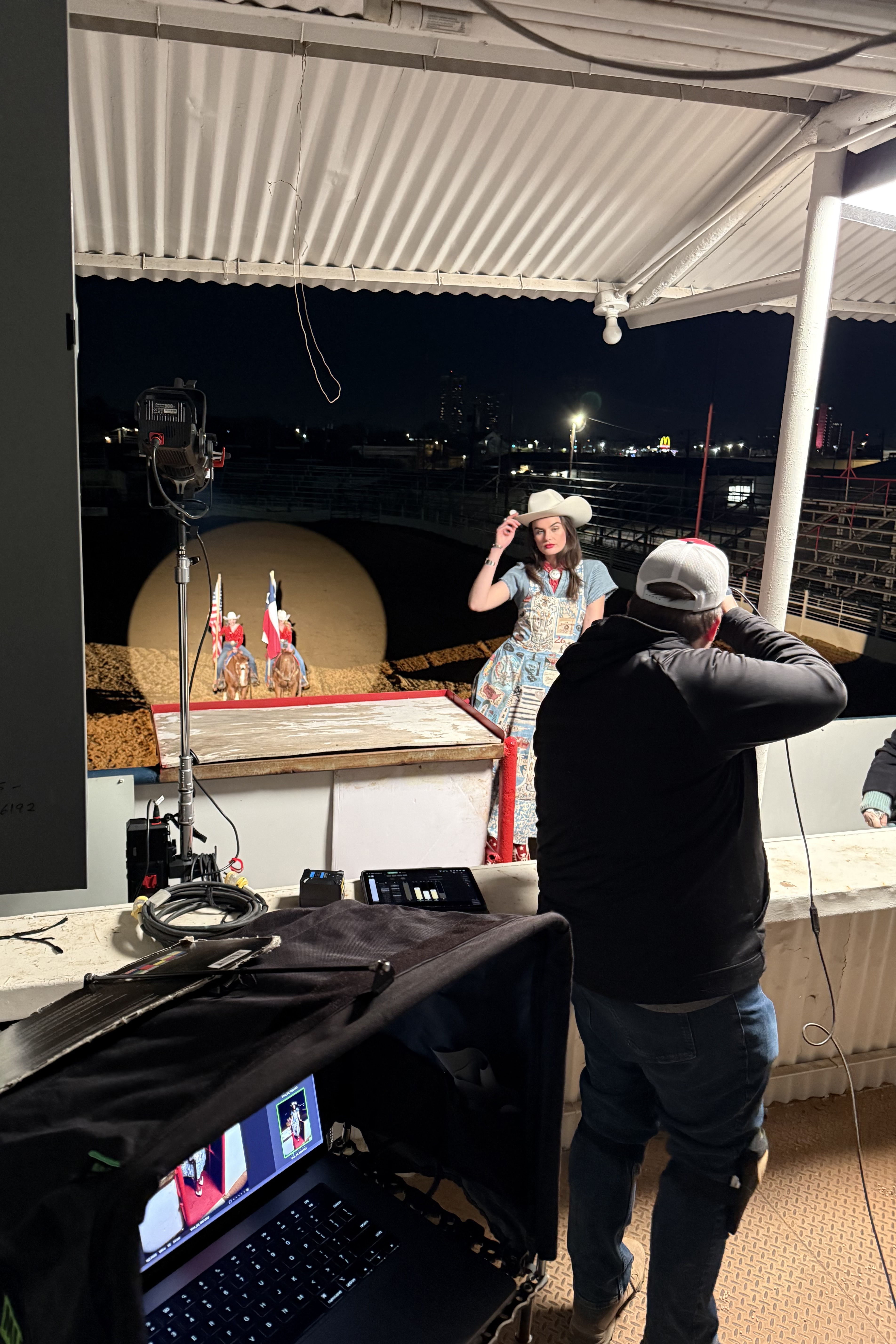 Mitchell shooting Kaylin at night in the arena with spotlights set up and pointed on her.