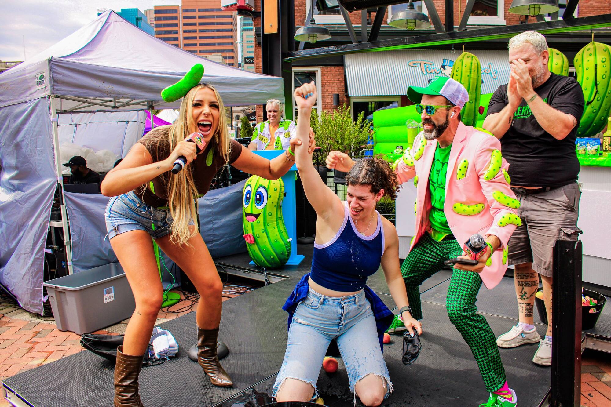 Pickle Up! gameshow host Hannah Rodriguez celebrating with the winner on stage at The Big Dill® Baltimore 2025, the #1 Pickle Party in the World®