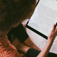 person reading a book on a tablet