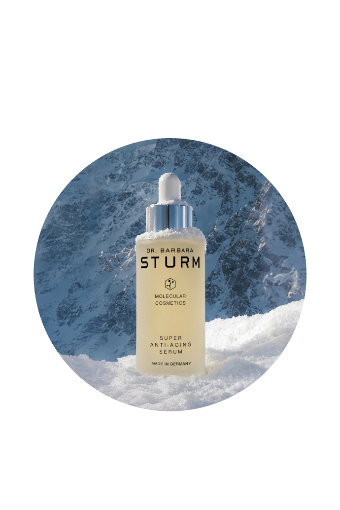 Bottle of skincare serum against a snowy mountain backdrop.