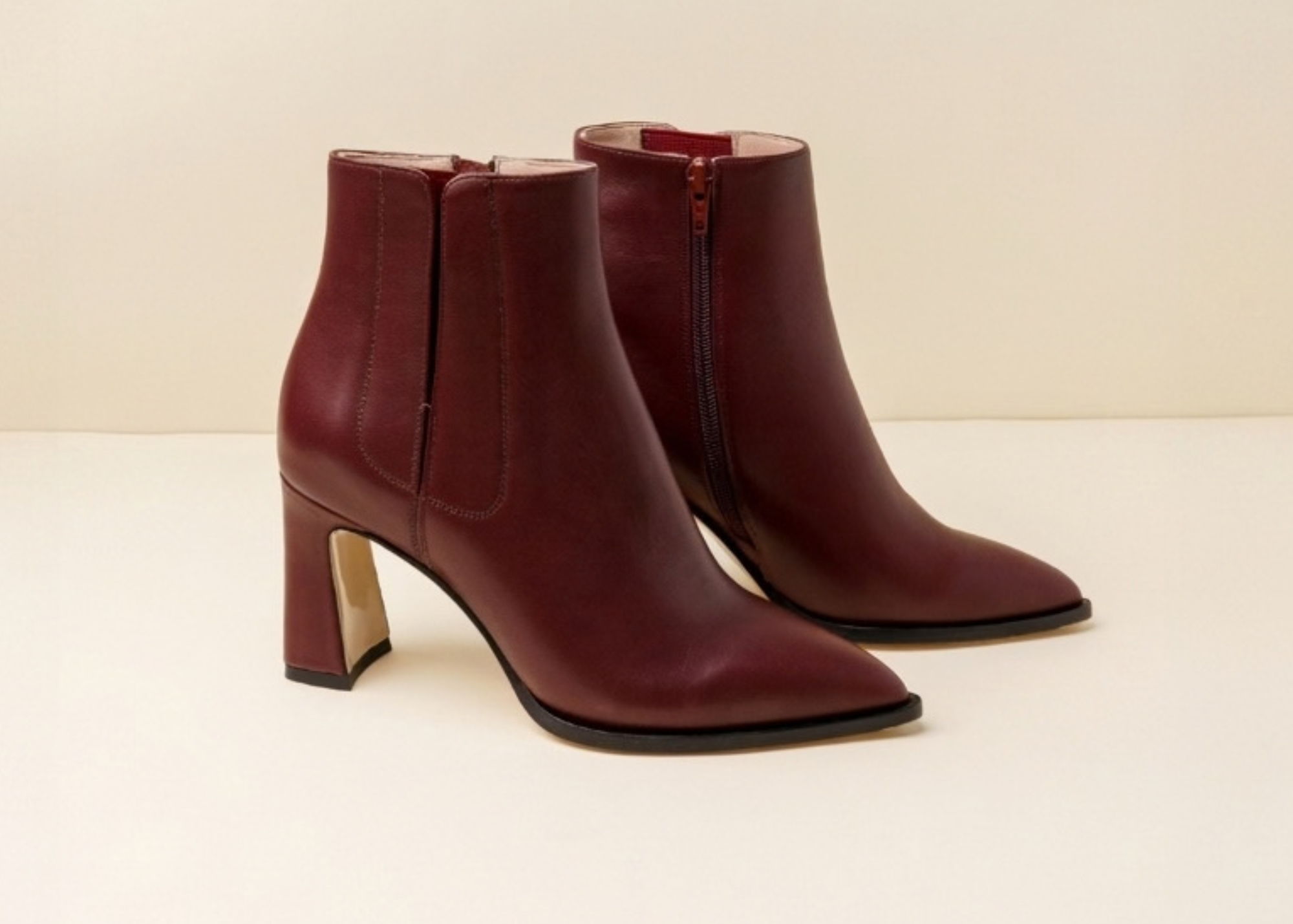 Maroon ankle boots with a high heel on a light background.