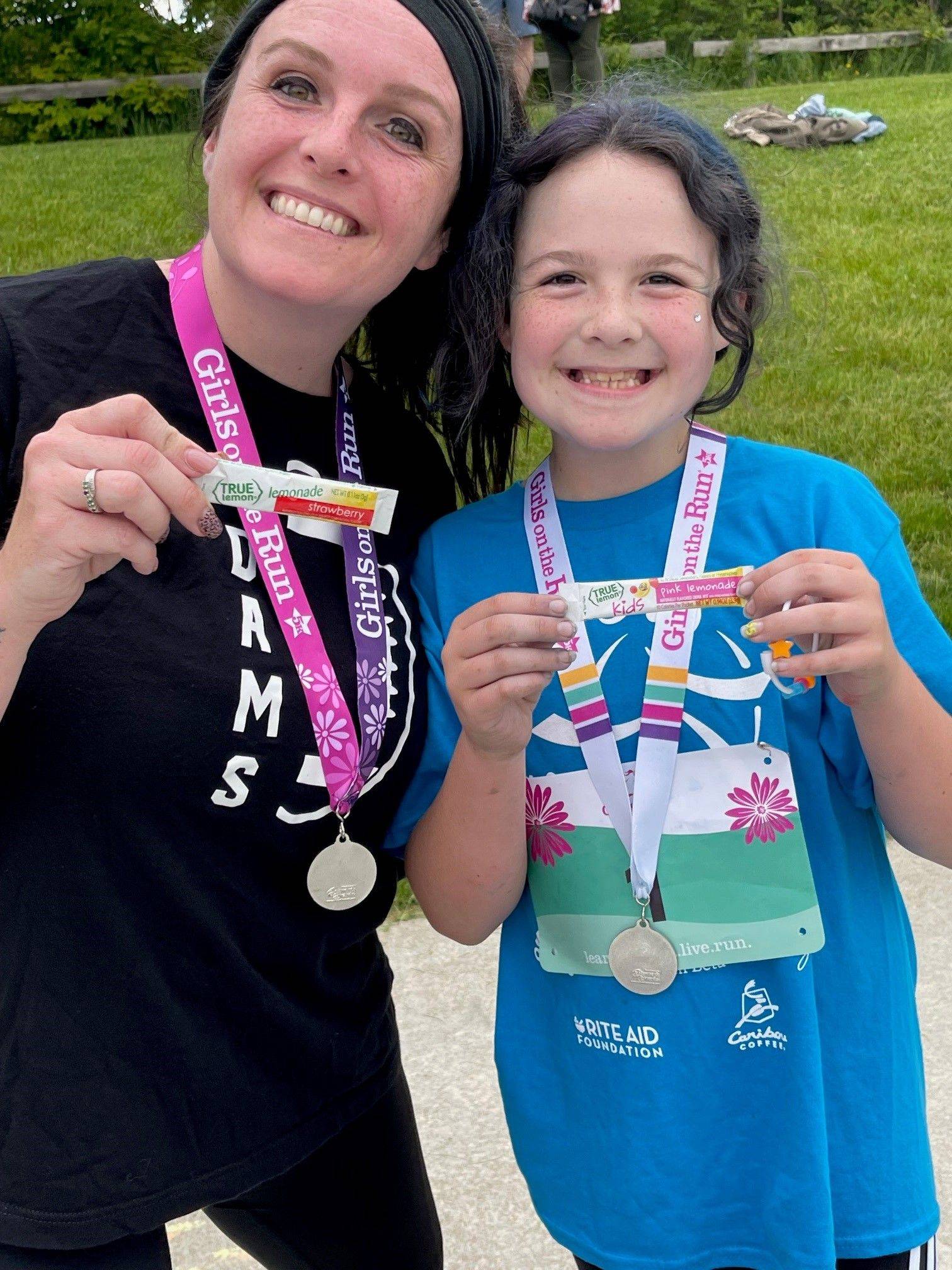 Mother and daughter with medals and packets of True Lemon after running the race