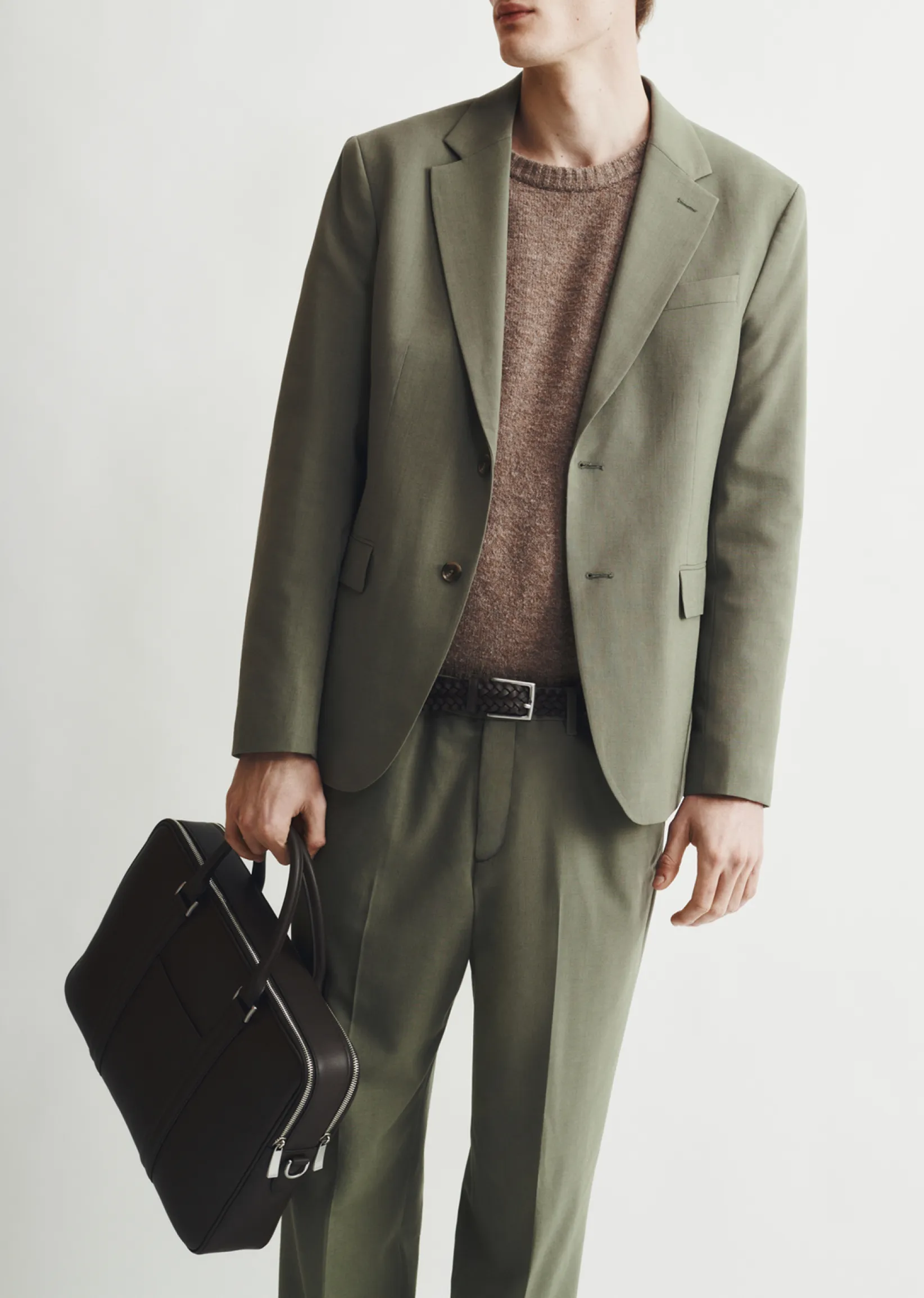 Man in a green suit holding a black briefcase.