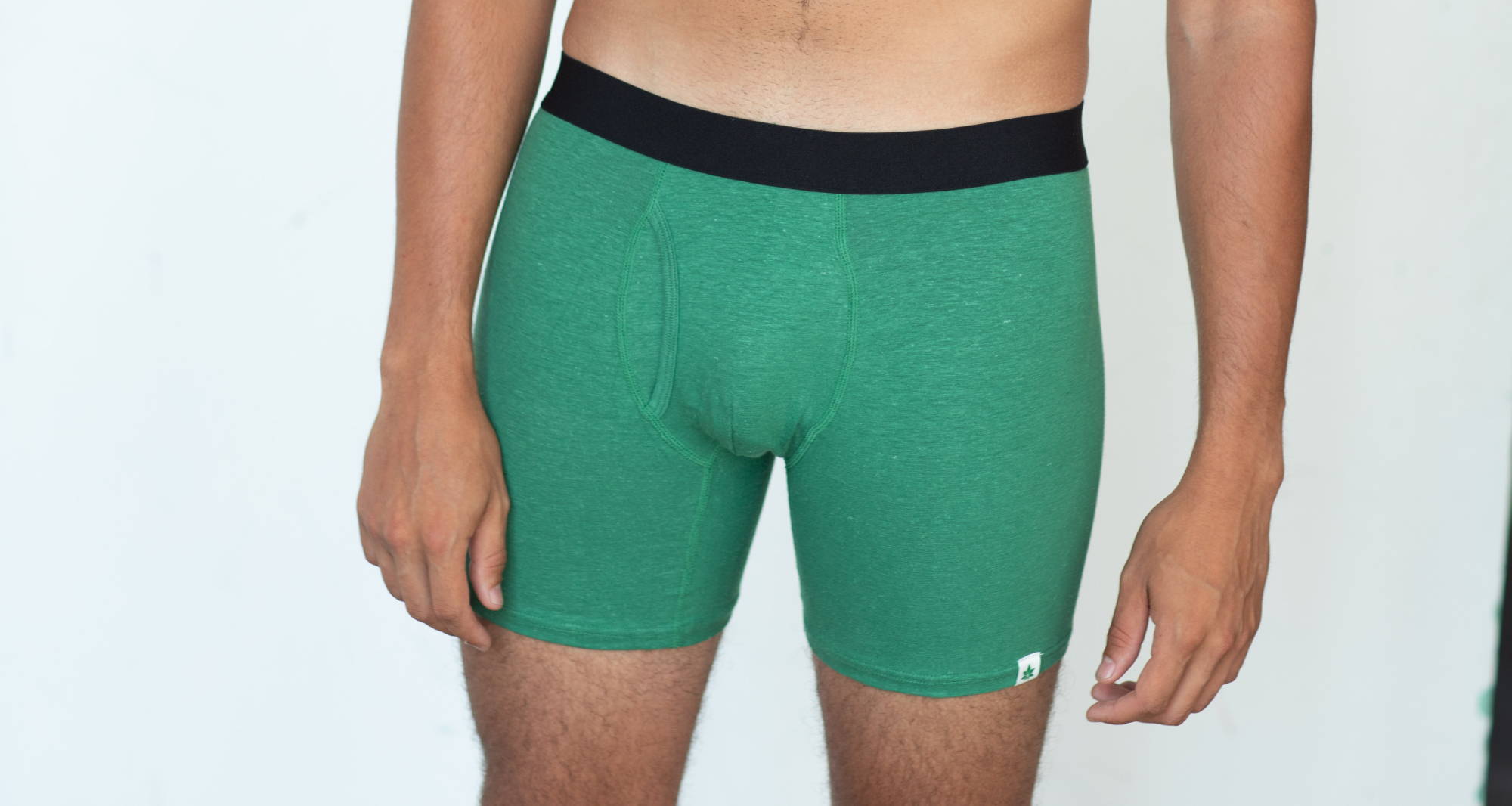 A close-up of a man’s torso and crotch in a pair of green boxer briefs.