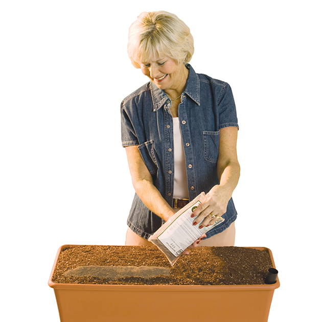 Woman adding fertilizer to EarthBox container gardening system