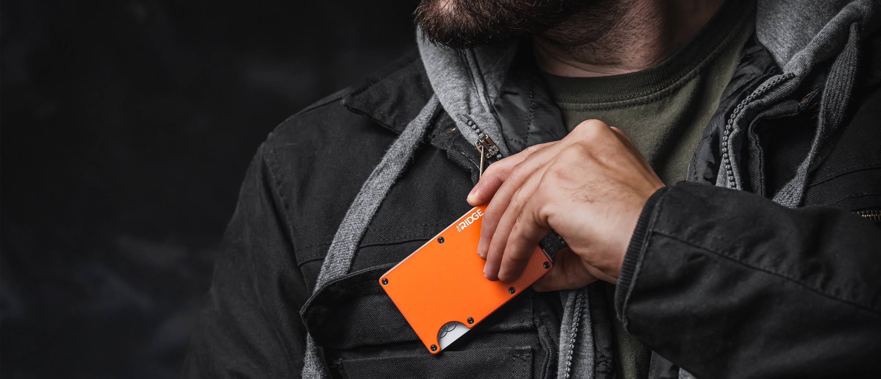 man holding a Basecamp Orange Ridge wallet in the chest