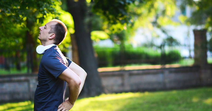 man holding back in park