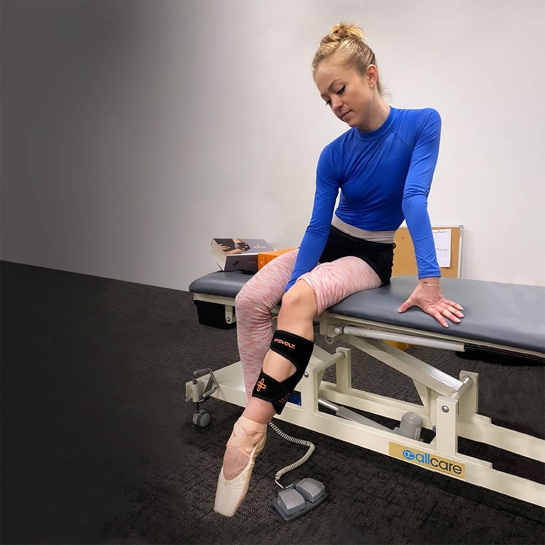Royal New Zealand Ballet dancer using the Myovolt Arm at the physio for Achilles soreness relief from ballet.