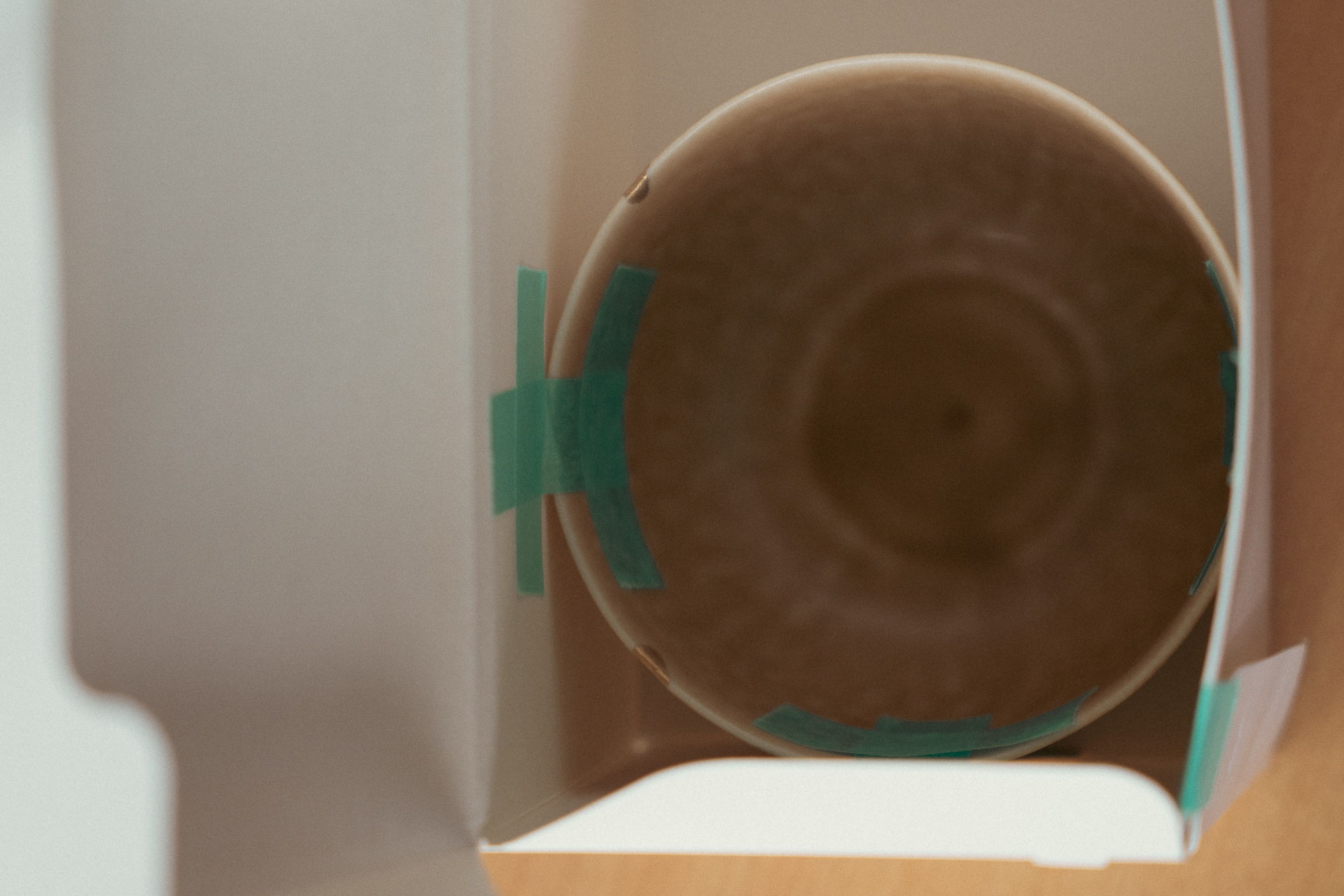 View of a circular object inside a cardboard box.