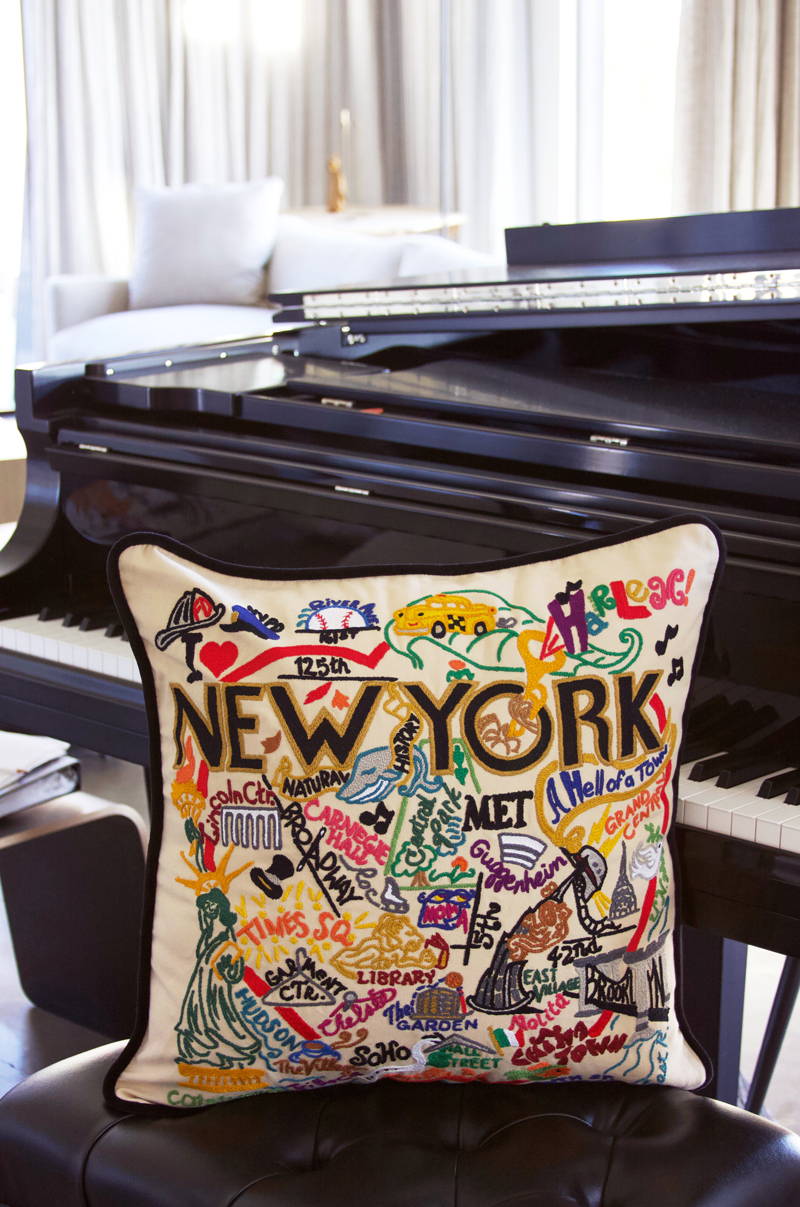 New York City pillow sitting on bench of baby grand piano