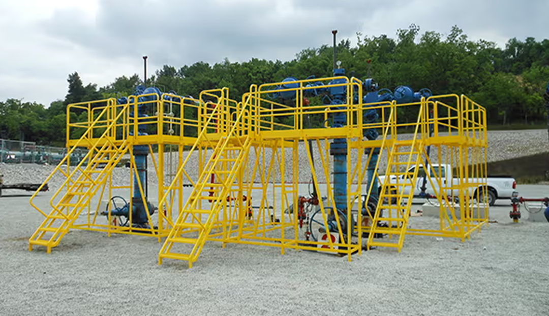 Custom multi-level oil well head access platform surrounding valves and controls for inspection and maintenance in oil and gas environments