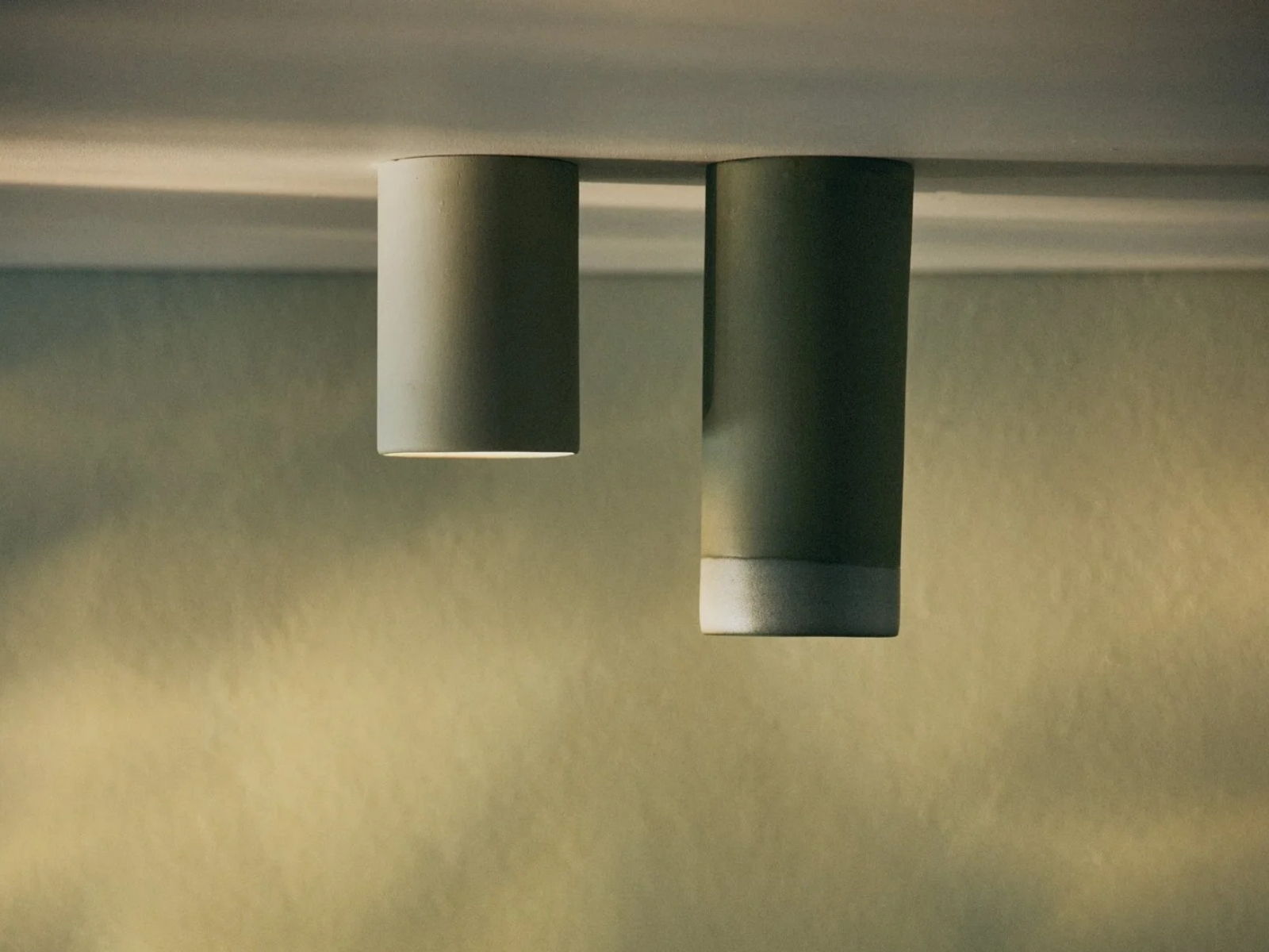 Two cylindrical ceramic ceiling lights against a textured background.