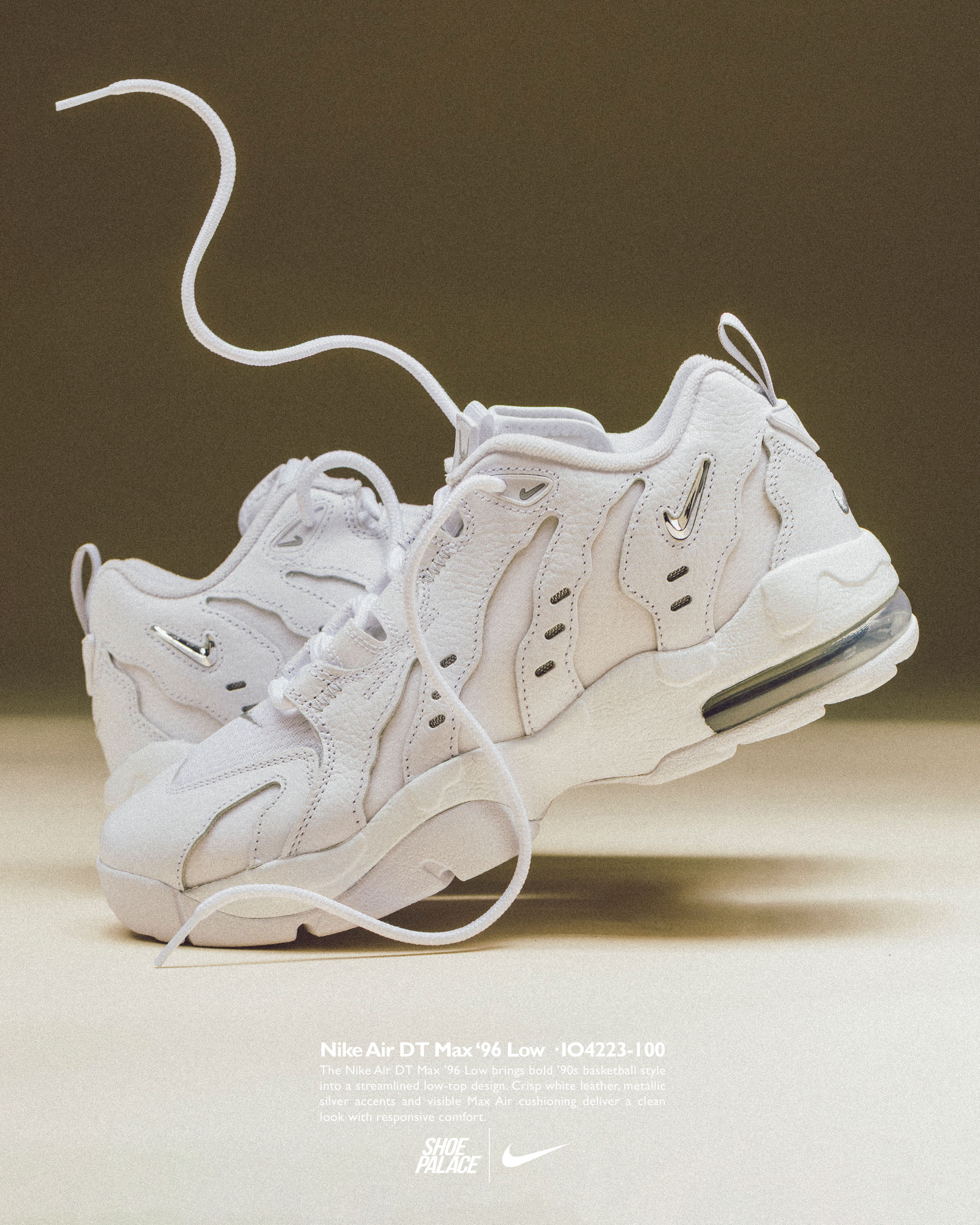 White sneakers with a dangling lace, displayed against a neutral background.