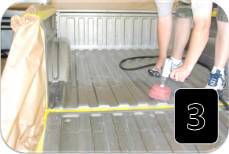 Technician prepping a truck bed with grease and wax remover before spray-on bedliner