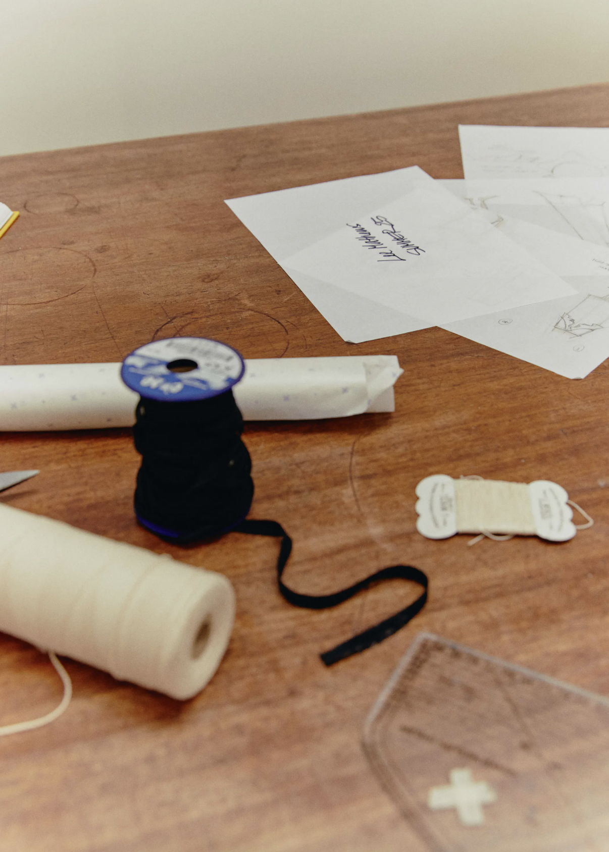 Spools of thread and sewing materials on a wooden table.