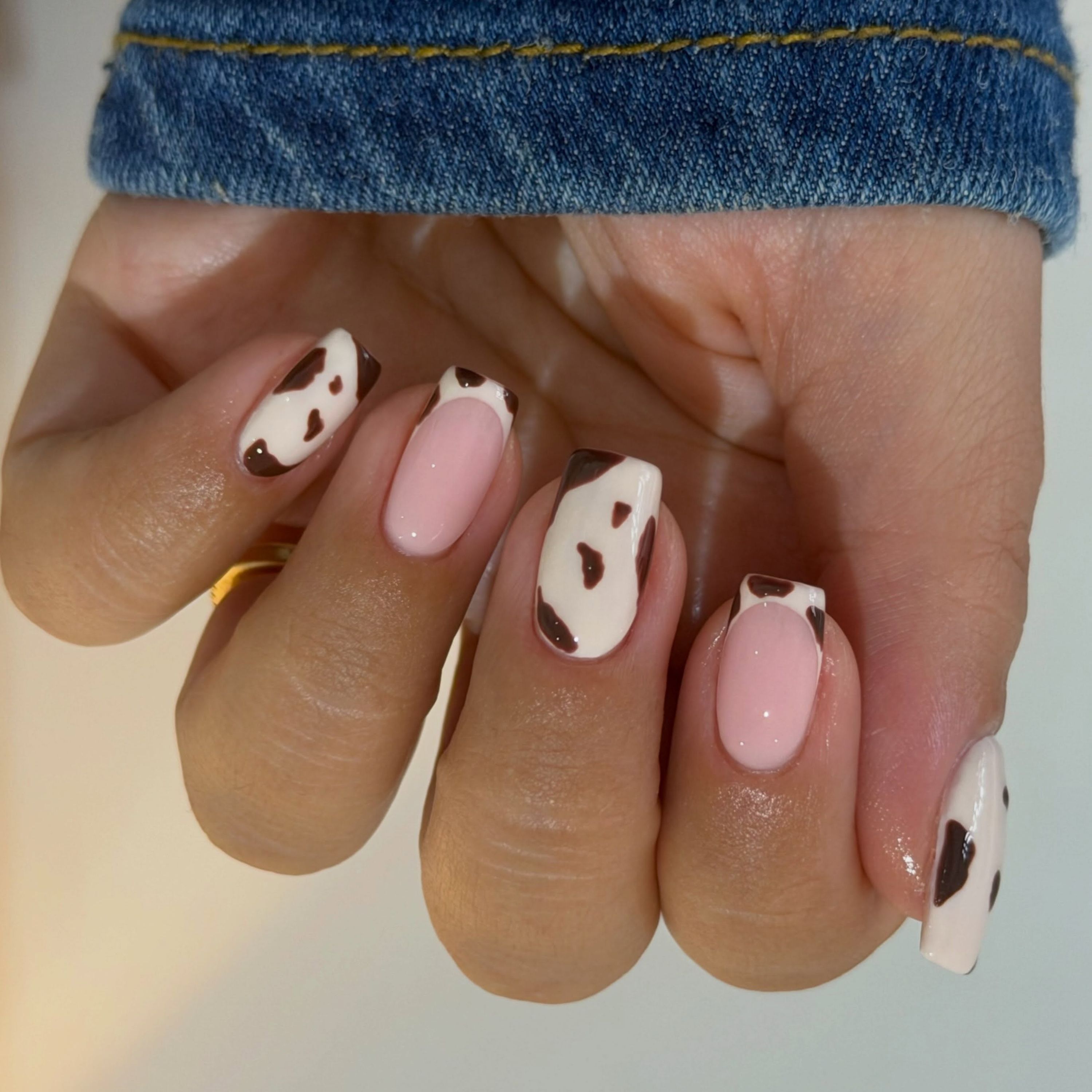 Cow print and nude-pink nails
